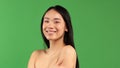 Close-up of asian beauty woman skin care. Beautiful young woman looking at camera and smiling. Isolated on green Royalty Free Stock Photo