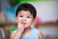 Close-up. An Asian boy uses his hand to eat food in his mouth. Concept of health care, disease occurrence and eating cleanliness.