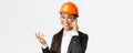 Close-up of asian businesswoman manage enterprise, engineer in safety helmet and suit having phone conversation, calling Royalty Free Stock Photo