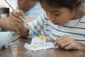 Close up asian child girl is concentrating to paint on small ceramic elephant with oil color. Royalty Free Stock Photo