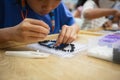 Close up on asian child girl hand making fusible beads thermo mosaic in pegboard that is a toy to develops the imagination of