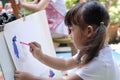 Close up of Asian child girl is painting on white paper. Royalty Free Stock Photo