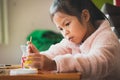 Close up asian child girl painting on plastic bottle with watercolor to recycle to be a flower pot. Kids arts and crafts creative Royalty Free Stock Photo