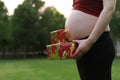 Close-up Asian Chinese pregnant woman`s belly present gift wrap beside belly Merry Christmas holiday concept expecting baby