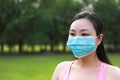 Close-up of Asian Eastern Chinese woman wear a mask COVID-19 virus outbreak in park forest outdoor nature grass meadow lawn