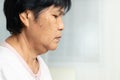 Close-up of Asian elder woman face with wrinkled skin condition. side view