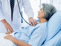 Close-up Asian elderly female patient dressed in light blue, smiling happily in bed.