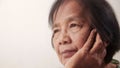 Close-up of an Asian elderly woman`s face Sitting with hands on cheeks, feeling stressed