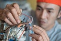 Close up of asian electronics repairman fixing broken wires
