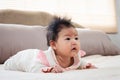 Close Up Asian girl lying face down in bed in her bedroom, after waking up, her head is raised looking for her mother. Asian Royalty Free Stock Photo