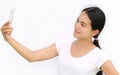 Close up asian girl taking pictures of herself through cell phone on white background Royalty Free Stock Photo