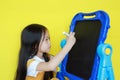 Close-up asian little girl writing on empty blackboard. Student and development concept Royalty Free Stock Photo