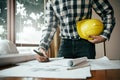 Close-up of asian male civil engineer working on blueprint architecture project on construction site at work desk in office