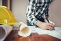 Close-up of asian male civil engineer working on blueprint architecture project on construction site at work desk in office