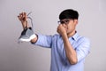 Close up asian man holding dirty stinky shoe with an expression of disgust. Healthcare concept Royalty Free Stock Photo