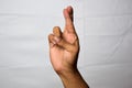 Close up Asian man shows hand gestures it means Fingers Crossed isolated on white background