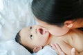 Close-up Asian mom playing and kissing her little baby boy on the bed Royalty Free Stock Photo
