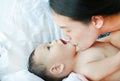 Close-up Asian mom playing and kissing her little baby boy on the bed Royalty Free Stock Photo