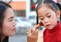 Close up Asian mother applying makeup on her daughter face Royalty Free Stock Photo