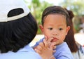 Close up Asian mother carrying her son with sucking finger in mouth Royalty Free Stock Photo