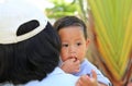 Close up Asian mother carrying her son with sucking finger in mouth Royalty Free Stock Photo