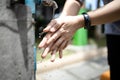 Close up,Asian people washing her hands,cleaning dirty hands from a faucet,tap water running weakly in public places in the city, Royalty Free Stock Photo