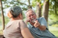 Close up, Asian senior couple having a good time while sitting outdoors in the park. Cheerful have a good time Royalty Free Stock Photo