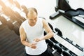 Close up Asian senior man holding bottle of water at a gym. Drinking water. Tired, thirstily. Royalty Free Stock Photo