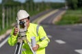 Close up of Asian surveyor engineer worker making measuring with theodolite on road works. survey engineer at road construction Royalty Free Stock Photo