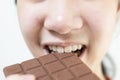 Close up,asian teenage girl eating tasty chocolate bar,deliciously sweet,enjoy the natural taste,smiling young woman holding Royalty Free Stock Photo