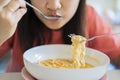 Close up Asian woman eating yummy hot and spicy instant noodle using chopsticks and bowl Royalty Free Stock Photo