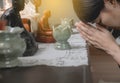 Close up of asian woman with hand in praying worship postures with buddha statue,Female prayer hands clasped together Royalty Free Stock Photo