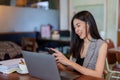 Close-up asian woman holding mobile phone in hand chatting with friends, plugged in headphones as listened music relieve stress Royalty Free Stock Photo