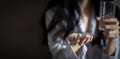 Close up Asian woman holding pill capsule and a glass of water in young female hand Royalty Free Stock Photo