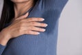 Close-up asian woman with hyperhidrosis sweating. Young asia woman with sweat stain on her clothes against grey background. Royalty Free Stock Photo