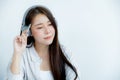 Close up of Asian woman portrait with headphones holding a pen looking straight ahead Royalty Free Stock Photo