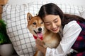 Close up Asian woman sitting hugging Shiba Inu dog in living room Royalty Free Stock Photo