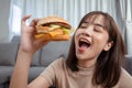 Close up asian woman takeaway eating junk food hamburger and pizza close-up shot in living room Royalty Free Stock Photo