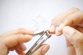 Close up Asian woman use steel tool cutting fingernails and cutted dirty nails on floor on white background Royalty Free Stock Photo