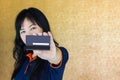 Close up Asian woman presenting back of debit or credit card with blank signature area Royalty Free Stock Photo