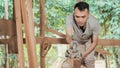 Close up of Asian workers working with electric wooden dowels while grinding wood