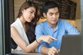 Asian yong couples surfing on interne with laptop in coffee shop