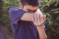 Close-up Asian young boy coughs in his elbow. Correct sneezing Royalty Free Stock Photo