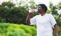 Sport runner black man wear athlete headphones he drinking water from a bottle Royalty Free Stock Photo