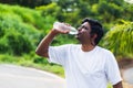 Sport runner black man wear athlete headphones he drinking water from a bottle Royalty Free Stock Photo