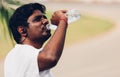 Sport runner black man wear athlete headphones he drinking water from a bottle Royalty Free Stock Photo