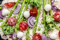 Close up asparagus tart. Raw pie filled with fresh asparagus, sweet peas, mozzarella and cherry tomatoes. Vegan food recipe Royalty Free Stock Photo