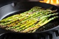 close-up of asparagus tips lightly charred in a cast-iron skillet