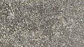 A detailed close-up of asphalt road texture with small stones creating a rough, grainy surface. Royalty Free Stock Photo