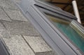 A close-up on asphalt roofing dimenshional shingles attaching the skylight example
